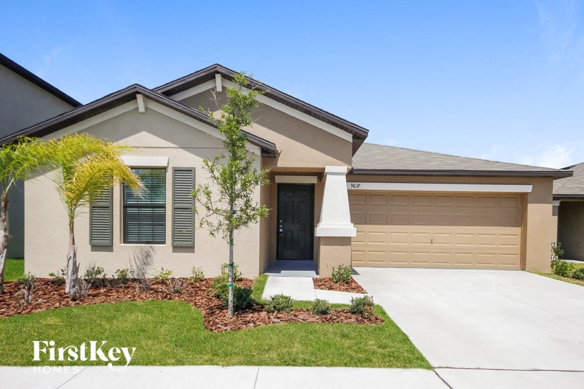A house with a garage and a driveway in front of it.