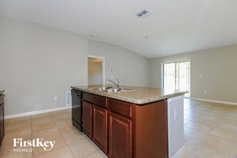 A kitchen with a brown counter top and a sink.