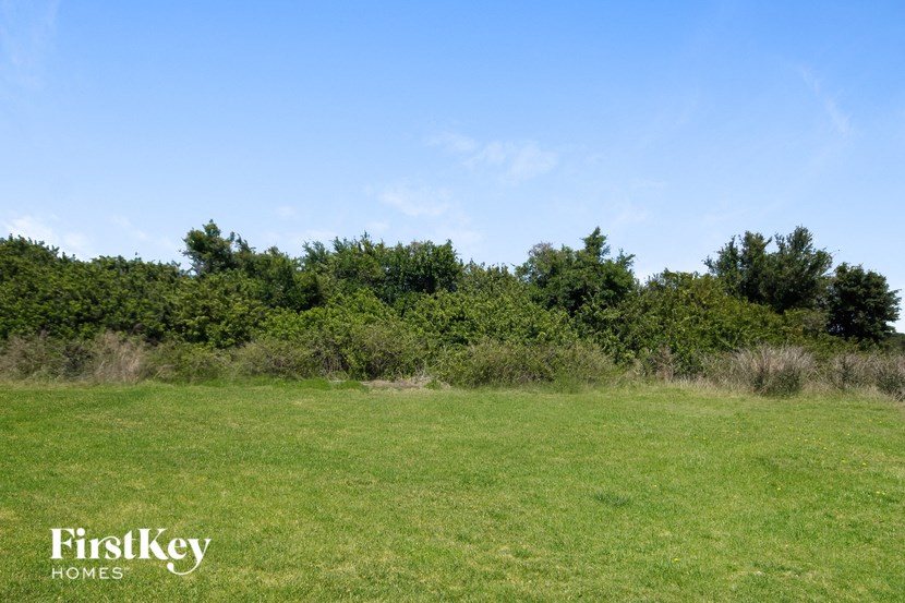 A field with trees in the background and the words "FirstKey Homes" on the bottom left.