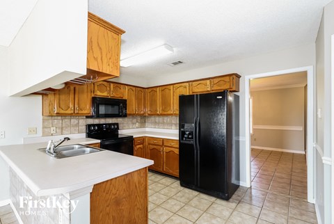 A kitchen with wooden cabinets and black appliances.