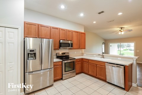 a kitchen with wooden cabinets and stainless steel appliances