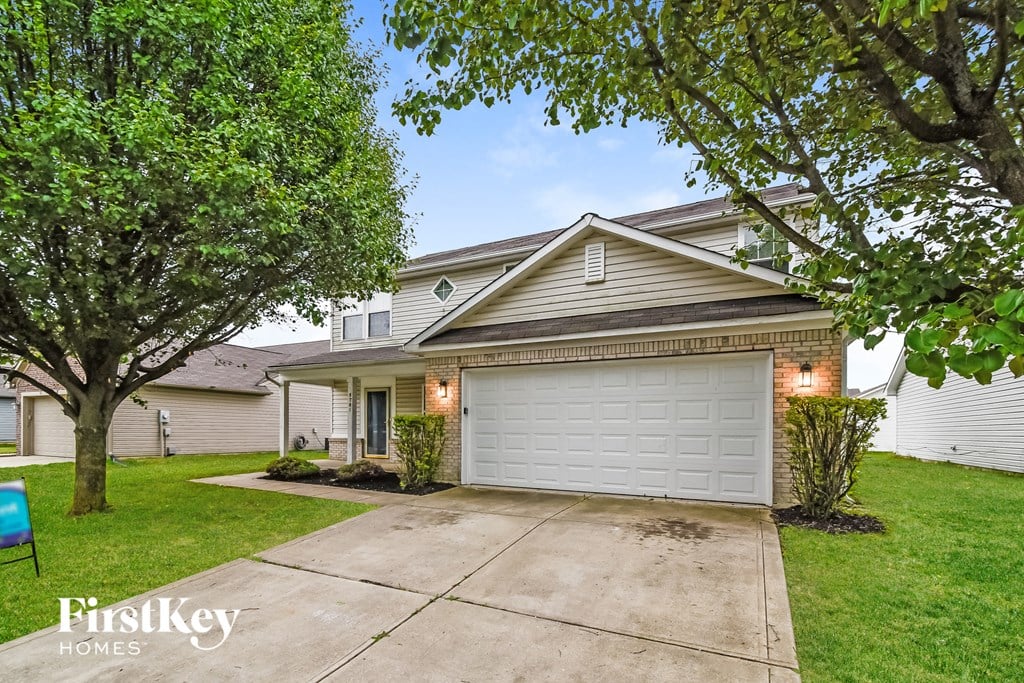 a home with a white garage door and a driveway