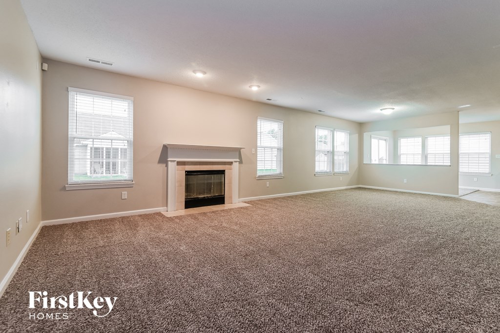the living room of an empty house with a fireplace