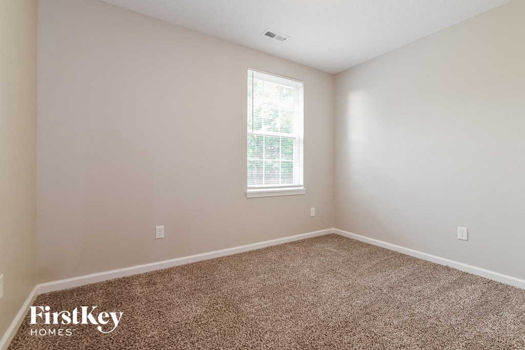 a empty room with carpet and a window
