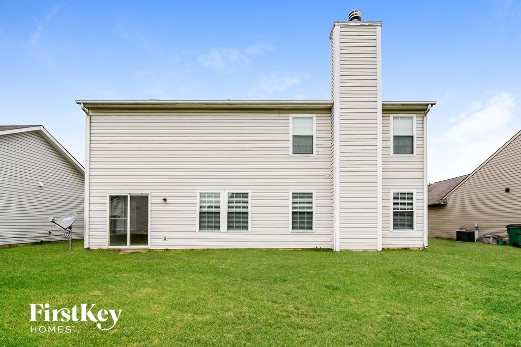 side view of a white house with white siding and green grass