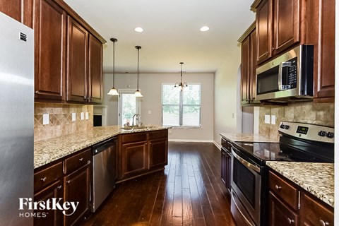 A kitchen with wooden cabinets and a granite countertop.