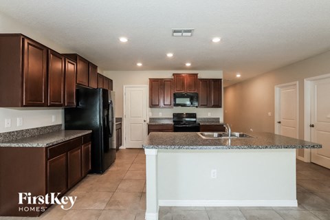 a kitchen with granite counter tops and black appliances