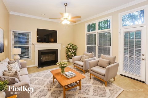 A living room with a fireplace and a grey couch.