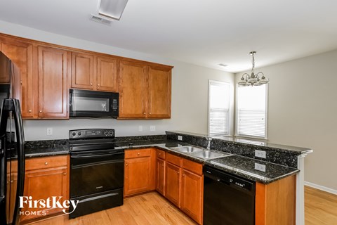 A kitchen with wooden cabinets and black appliances.