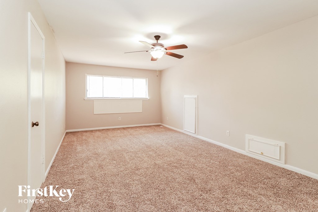 a empty room with a ceiling fan and a window