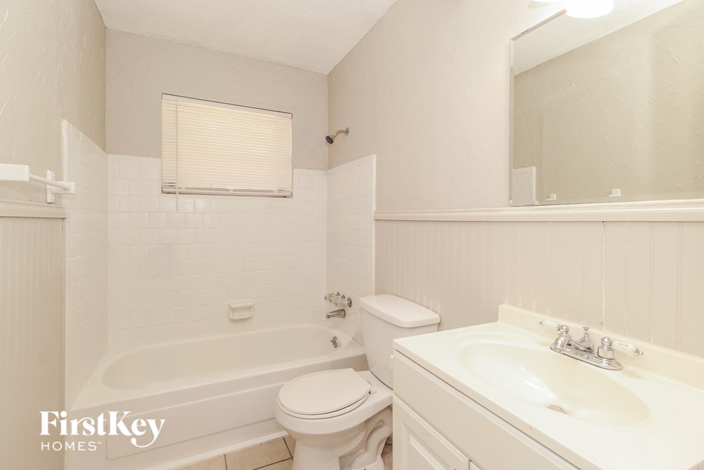 a white bathroom with a sink toilet and tub