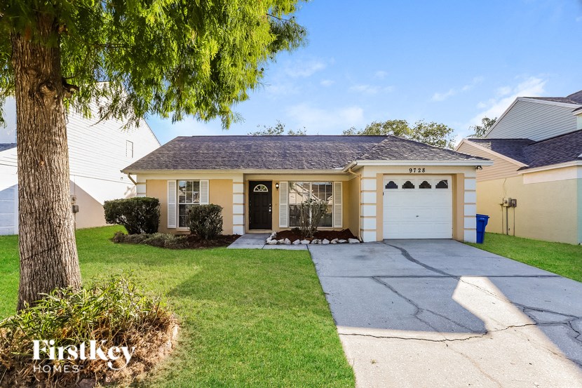 a yellow house with a driveway and a white garage door