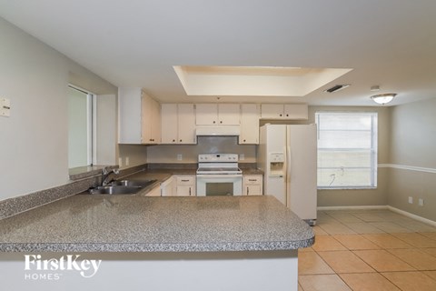 a large kitchen with granite counter tops and white cabinets