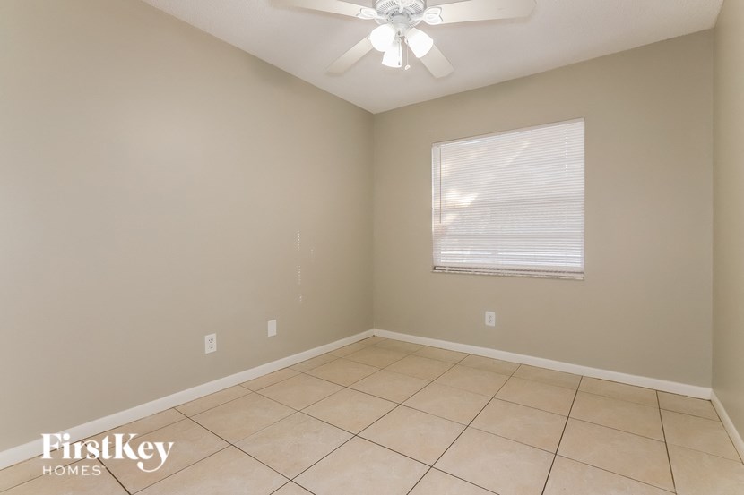 a empty room with a ceiling fan and a window