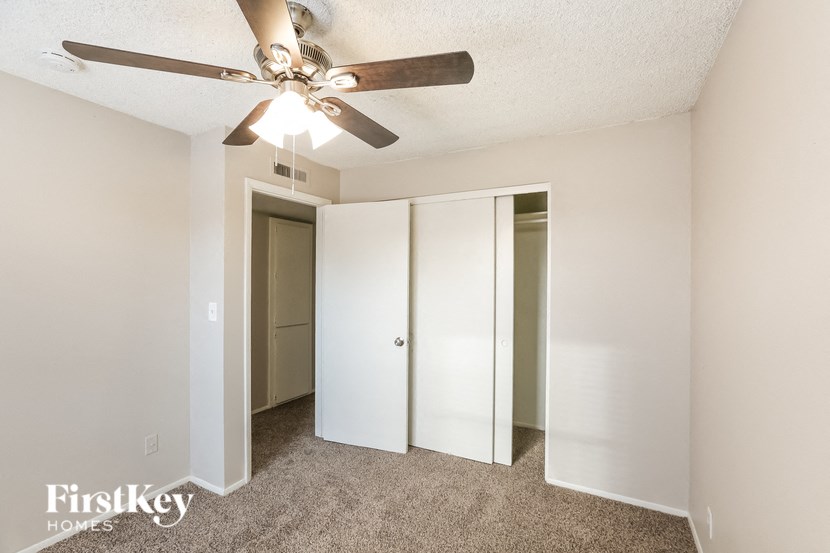a bedroom with a ceiling fan and a closet