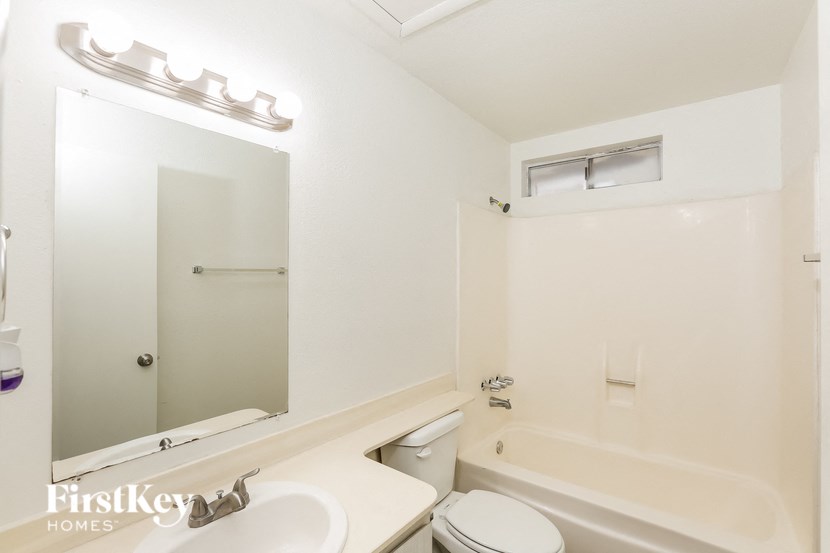 a bathroom with a sink toilet and a mirror