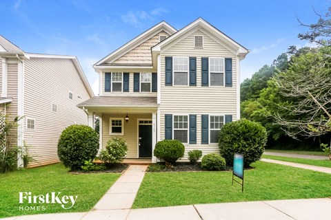 A two-story house with a front yard and a sign that says "FirstKey Homes".