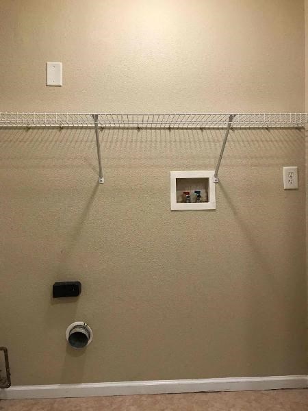 A wall with a shelf and a vent.