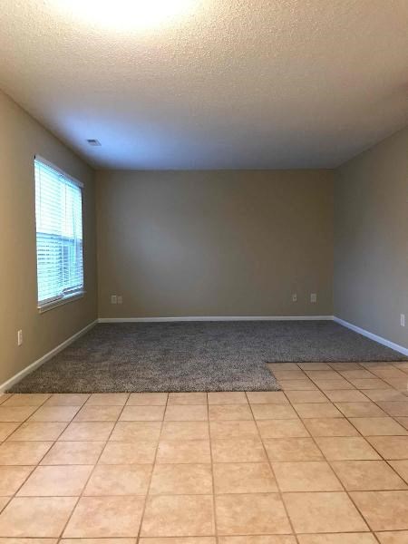 A room with tiled flooring and a window.