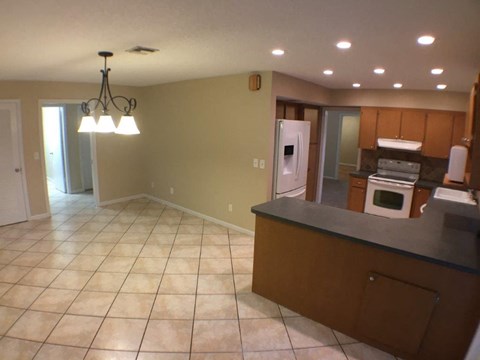 A kitchen with a tile floor and a chandelier.