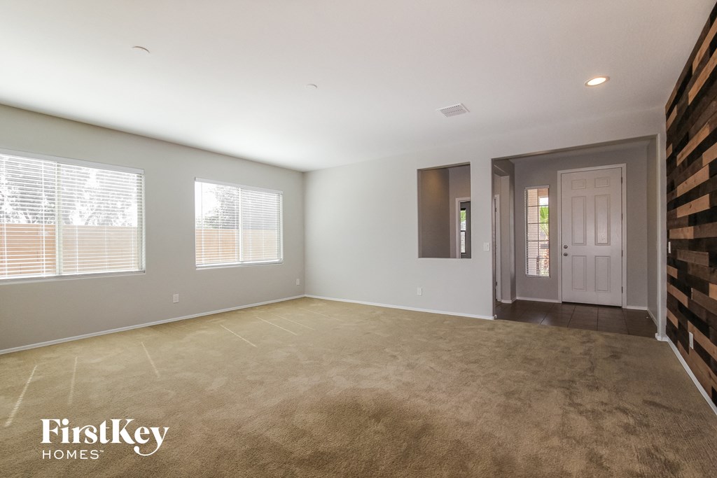 an empty living room with a white door and a window