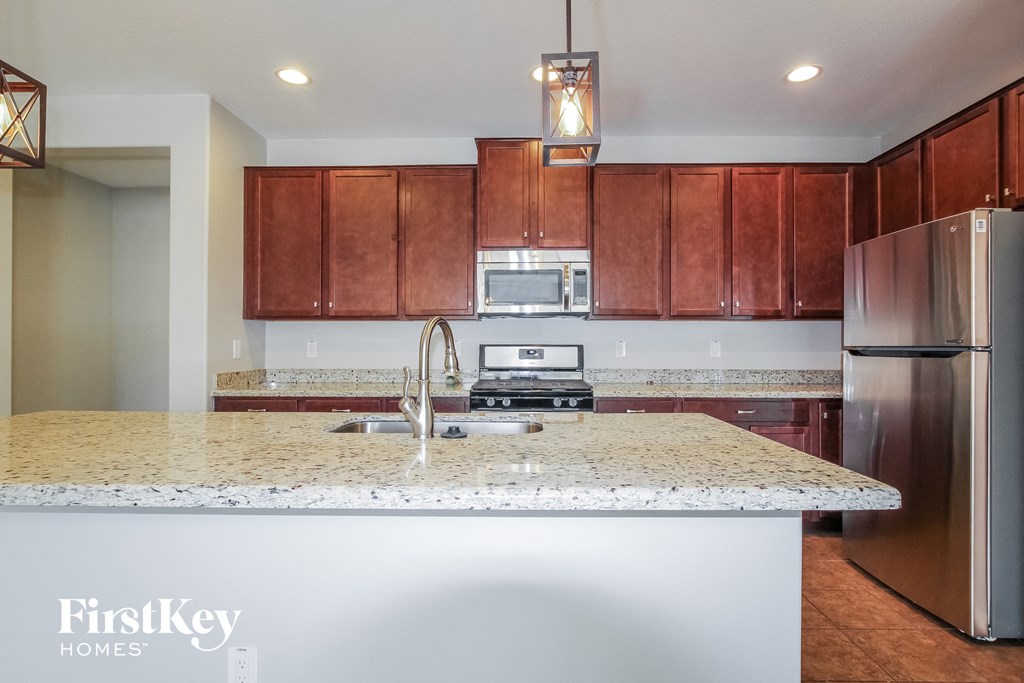 a kitchen with granite counter tops and wooden cabinets