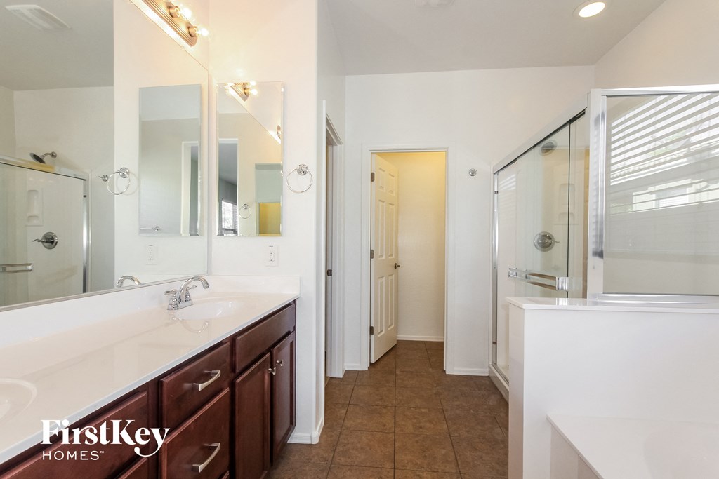 a bathroom with two sinks and a shower and a mirror