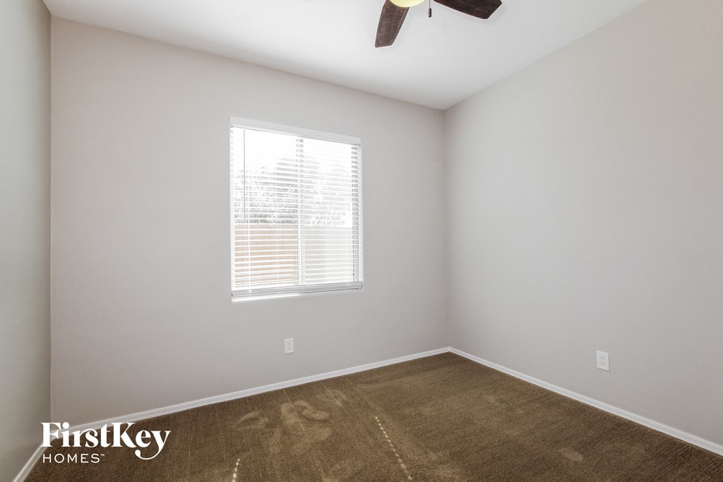 a empty room with a ceiling fan and a window