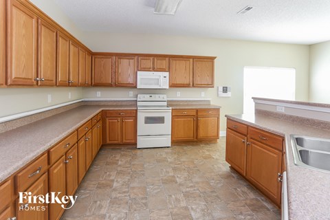 A kitchen with wooden cabinets and a tile floor.