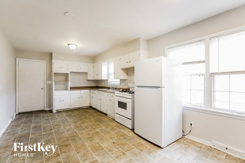 A kitchen with white appliances and cabinets is shown.