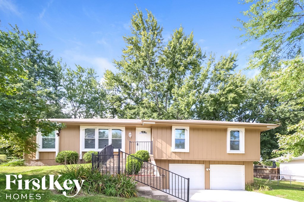 front view of a home with trees and a driveway