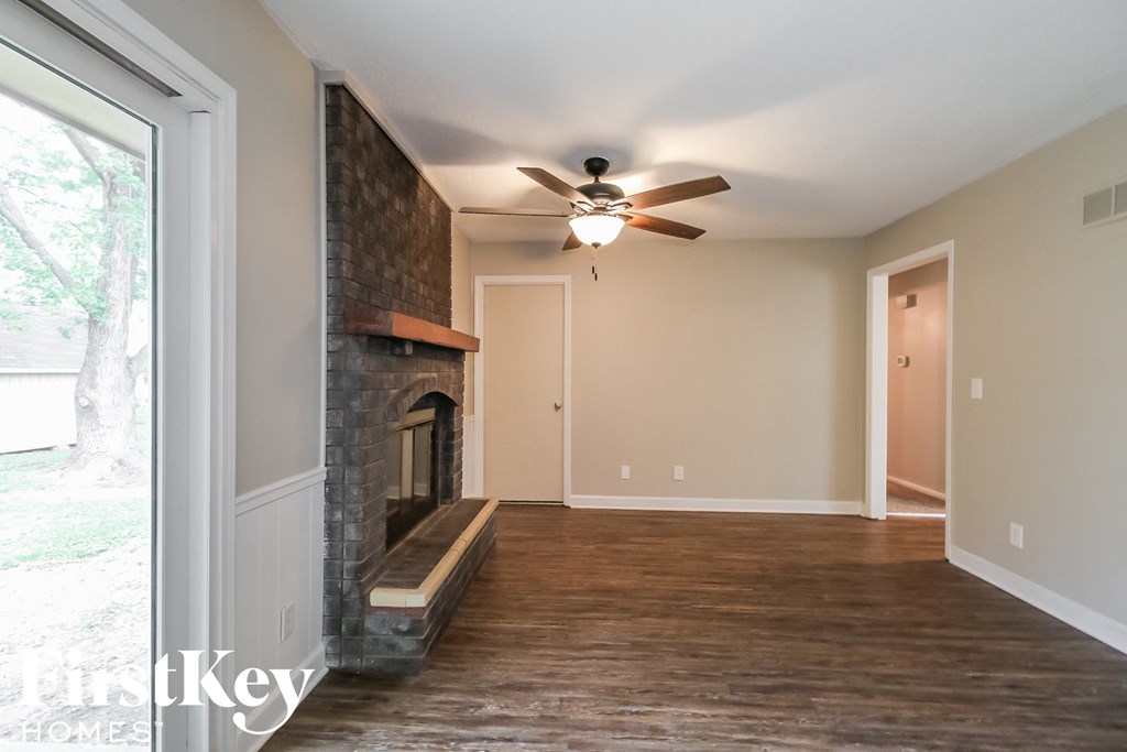 a living room with a fireplace and a ceiling fan