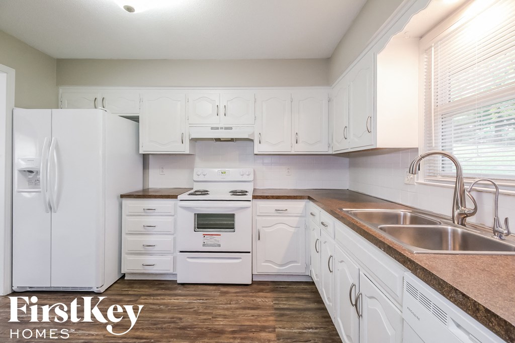 a white kitchen with white appliances and white cabinets