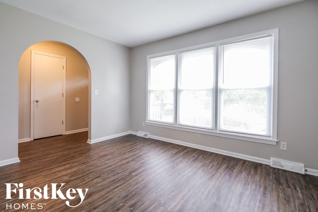 a living room with wood floors and large windows