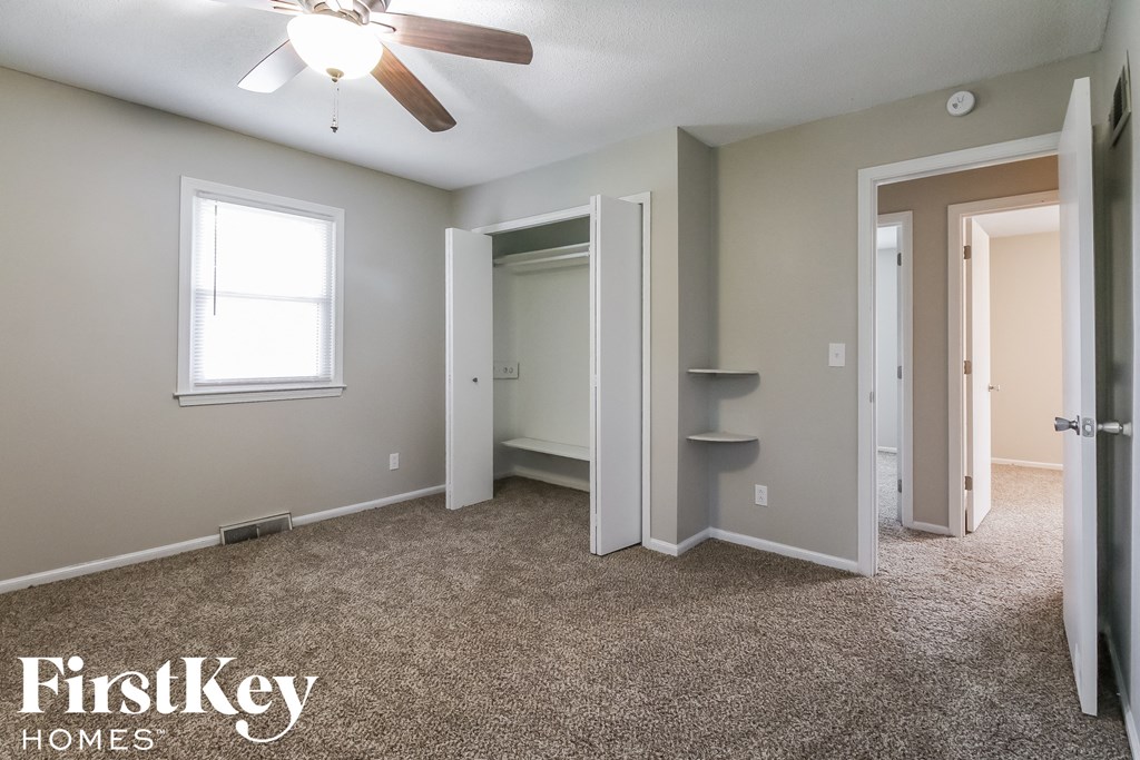 a room with a carpeted floor and a ceiling fan