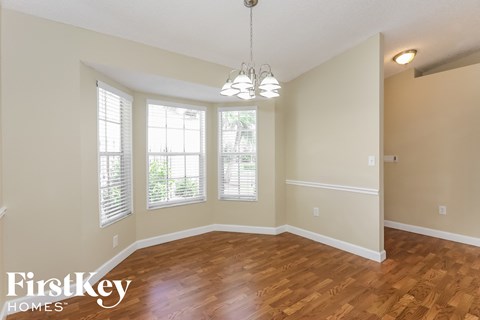 the dining room and living room with hardwood flooring and windows