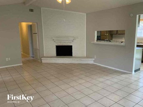 a living room with a fireplace and a tiled floor