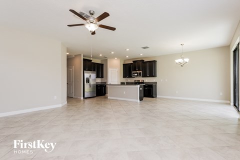 an empty kitchen and living room with a ceiling fan