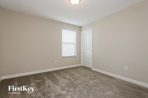 a bedroom with a carpeted floor and a white door