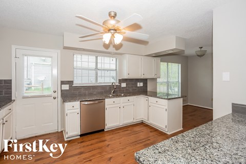 A kitchen with a fan and a dishwasher.