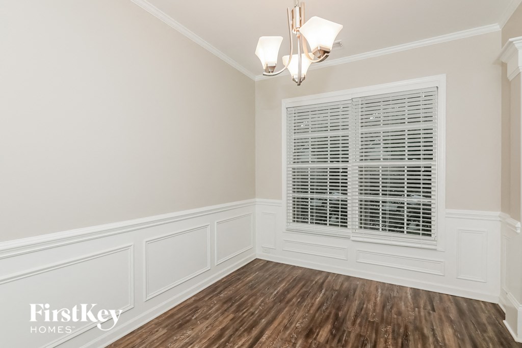 a dining room with white walls and a window
