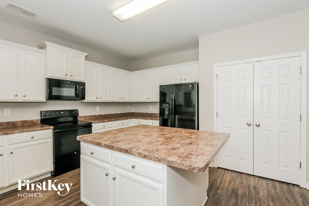 a kitchen with white cabinets and a granite counter top