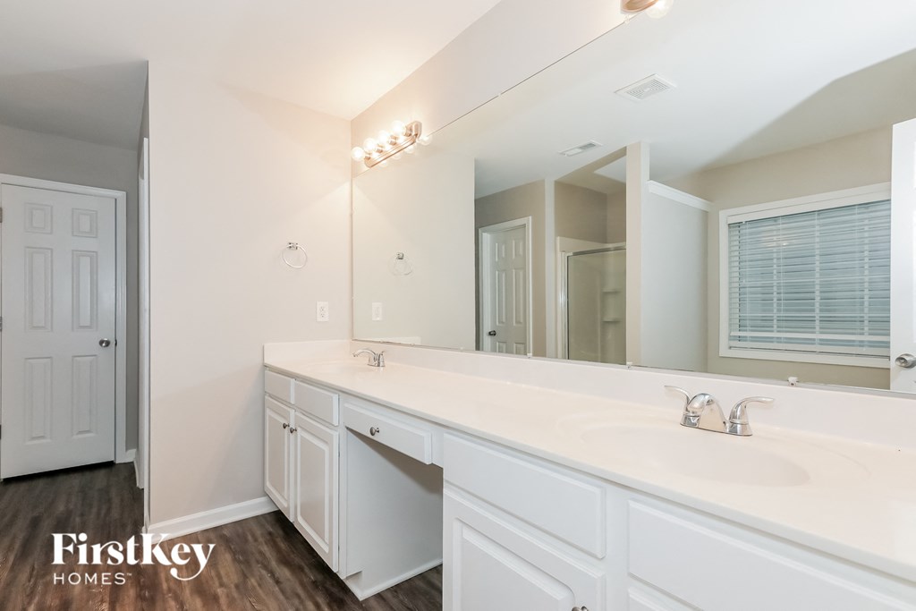 a bathroom with a large mirror and a white sink