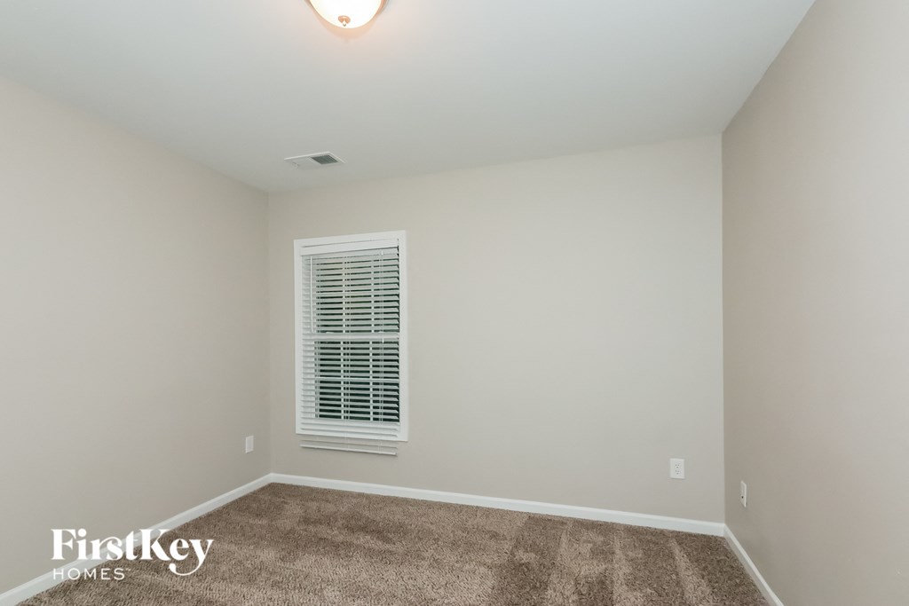 a empty room with carpet and a window