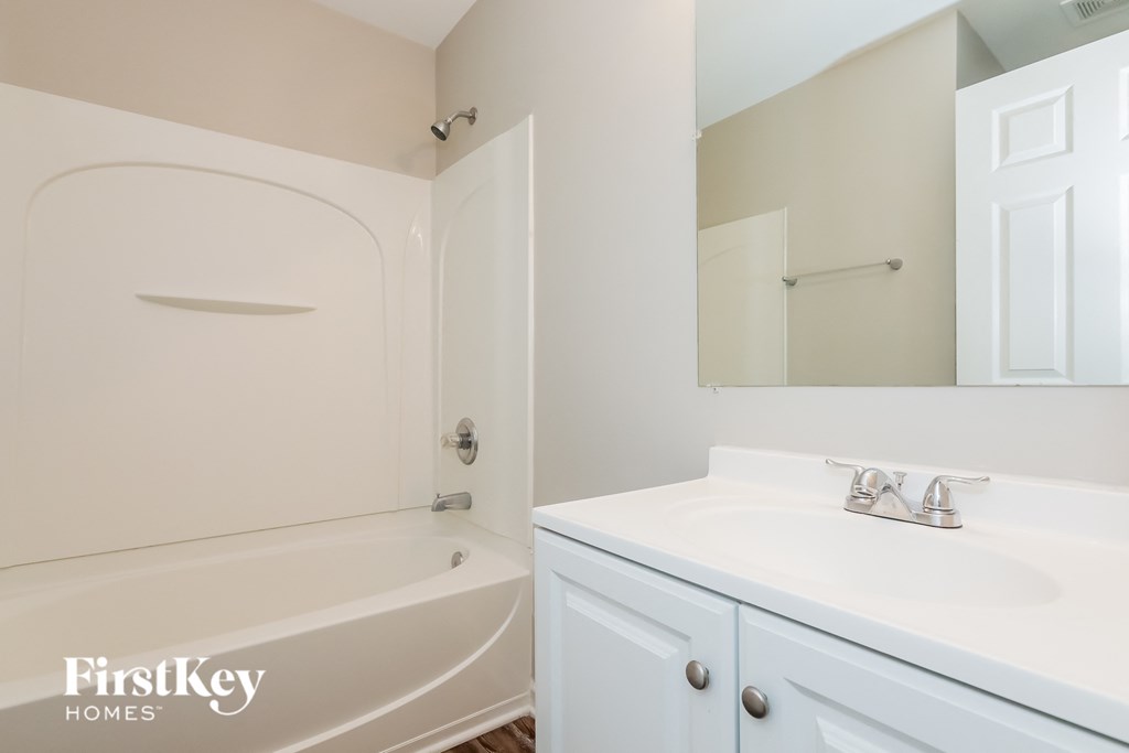 a bathroom with a sink and a tub and a mirror