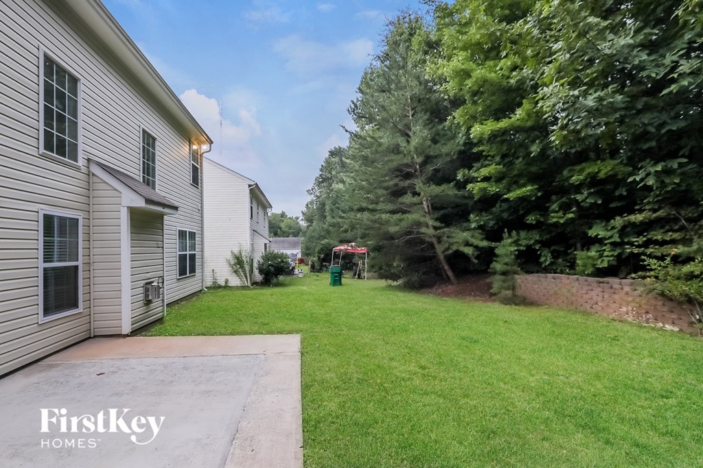 a backyard with a yard and a house with a lawn and trees