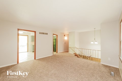 A spacious room with a staircase and a window.