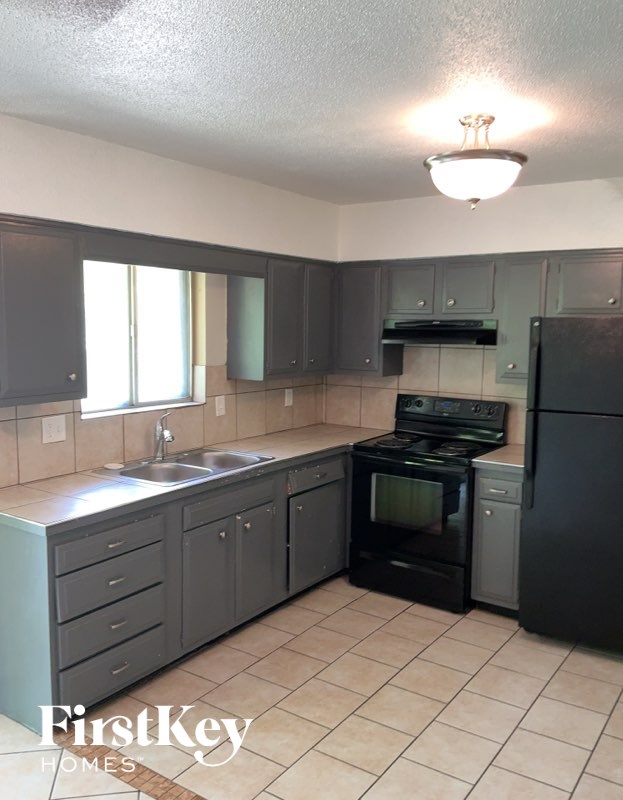 A kitchen with black appliances and cabinets.