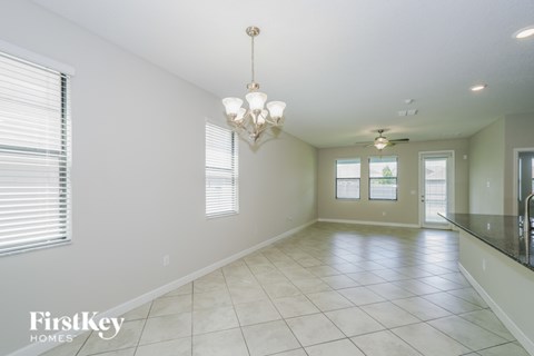 A spacious room with a chandelier and a fan.