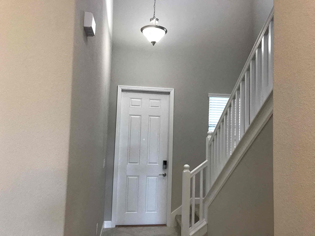 A white door is at the end of a hallway.